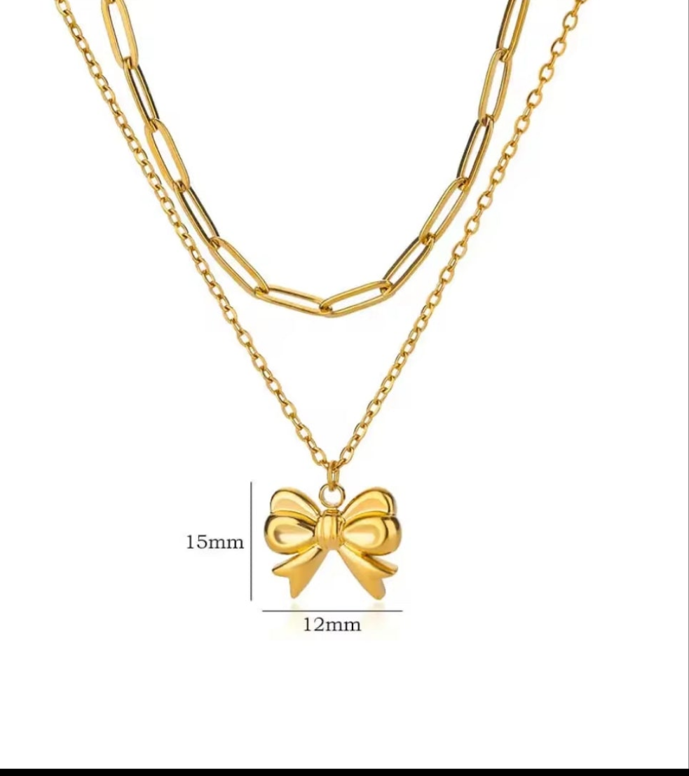 Gold necklace with a bow pendant on a white background