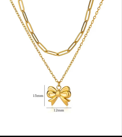 Gold necklace with a bow pendant on a white background