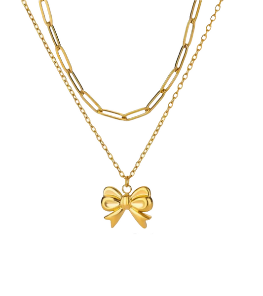 Gold necklace with a bow pendant on a white background